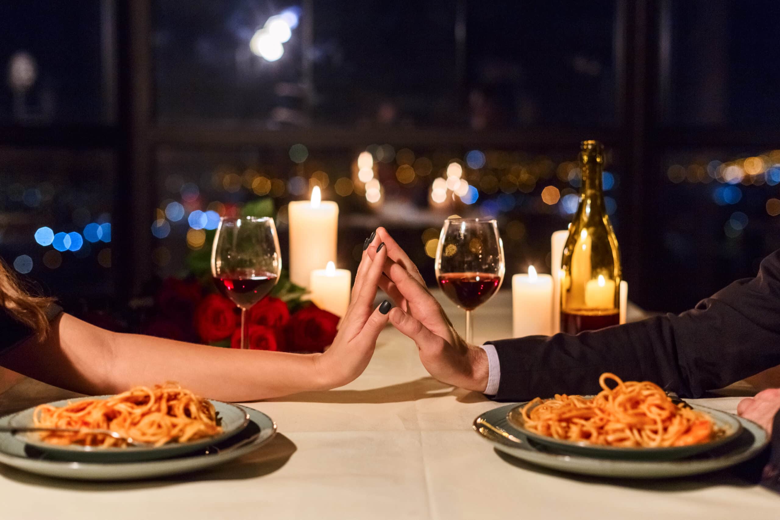 Couple having dinner at a restaurant and touching hands